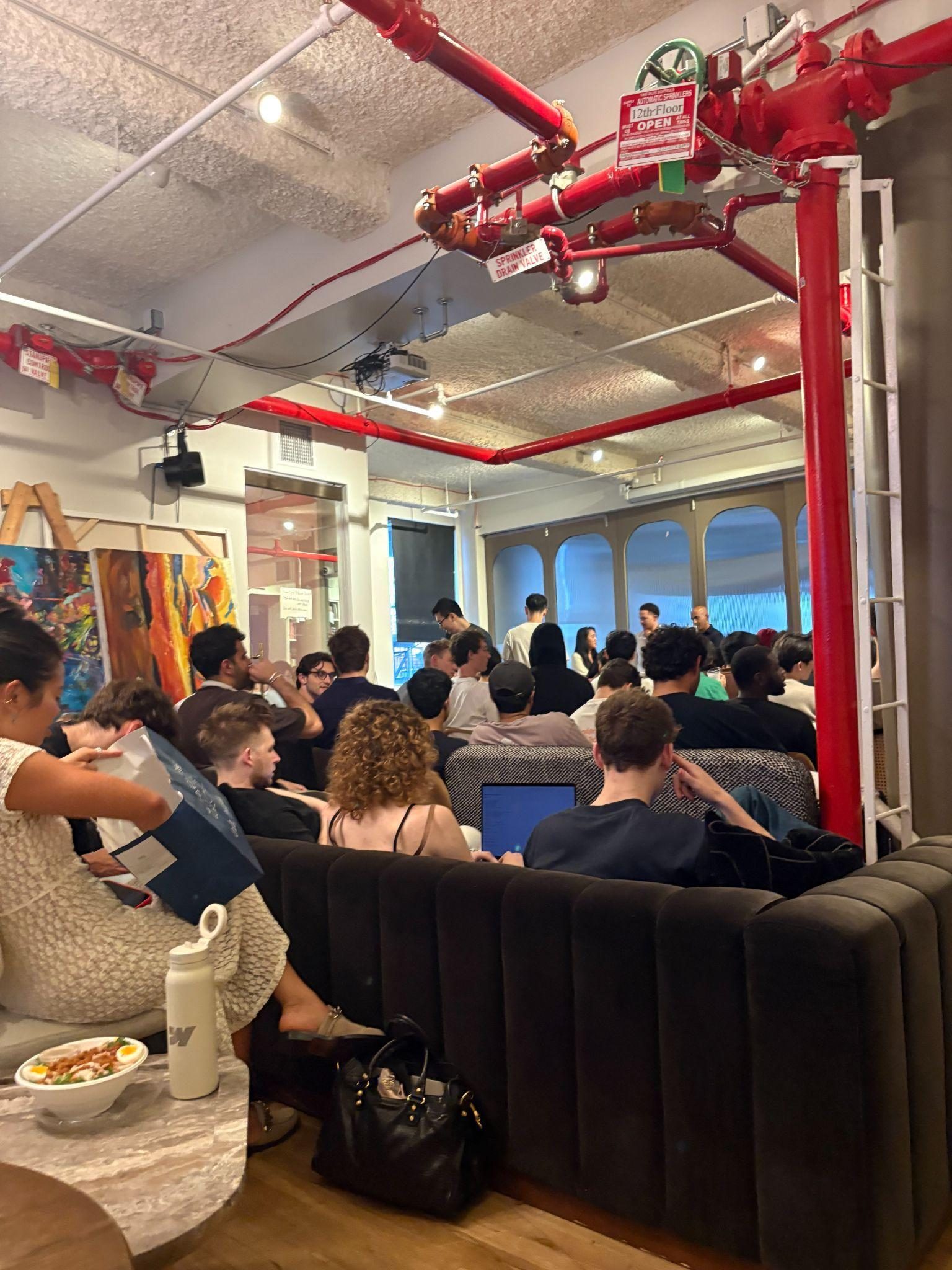 Jake at an a16z event, a crowded room of founders networking
